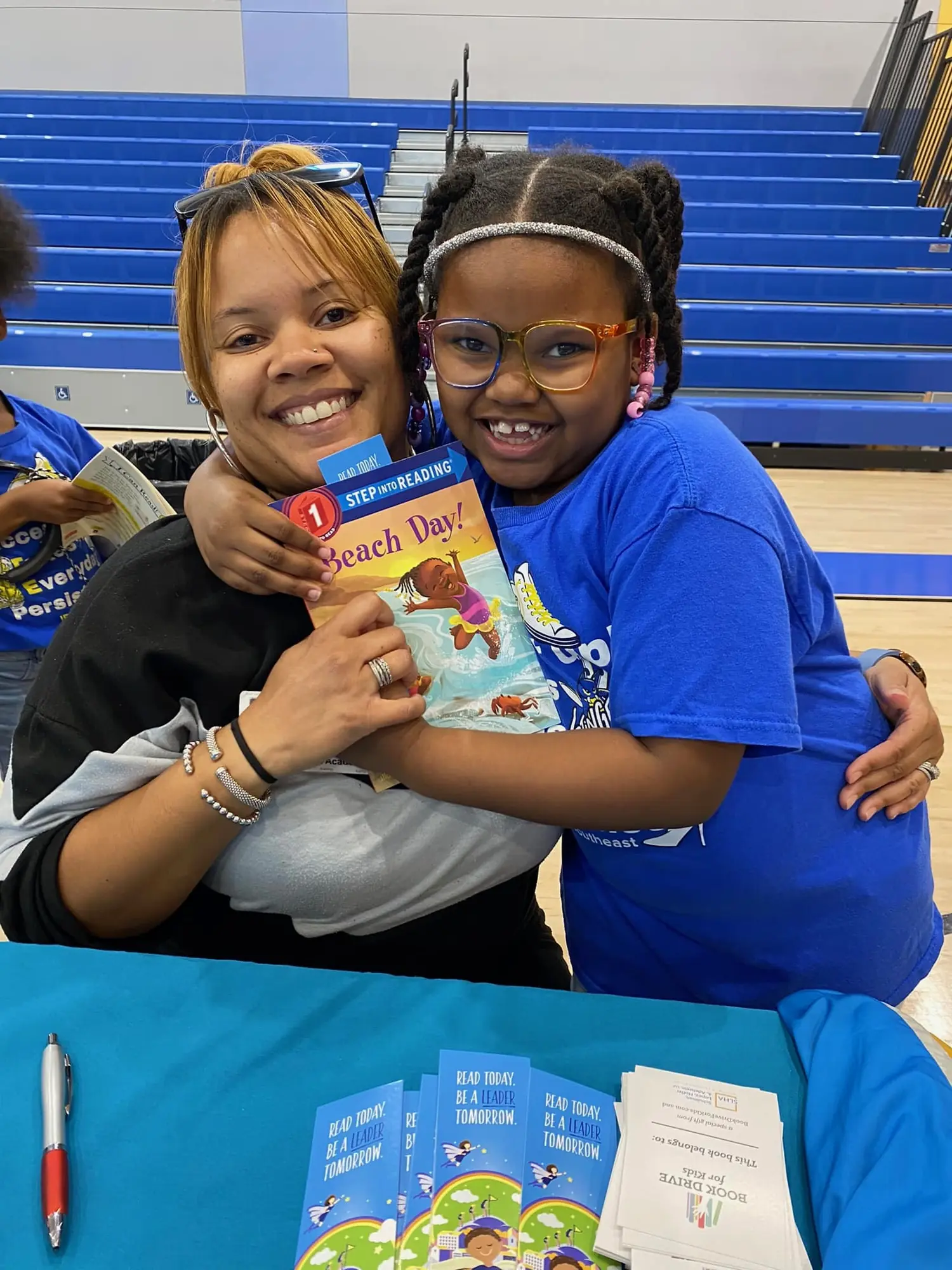 A student shows off the brand-new book she chose at a DFW book fair